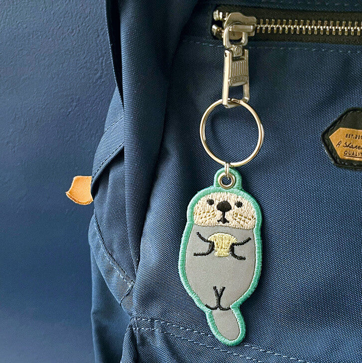 Keychain with a seal design attached to a blue backpack.