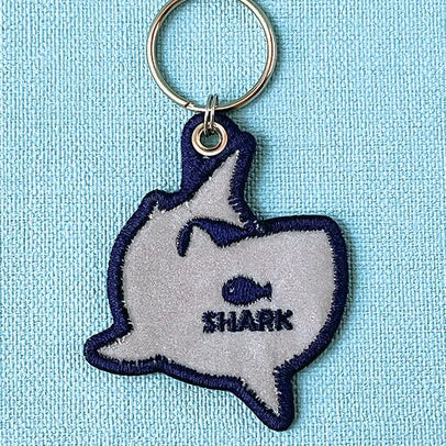 Keychain with shark design on a light blue background