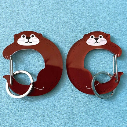 Two cartoon-style otter-shaped carabiners on a blue background