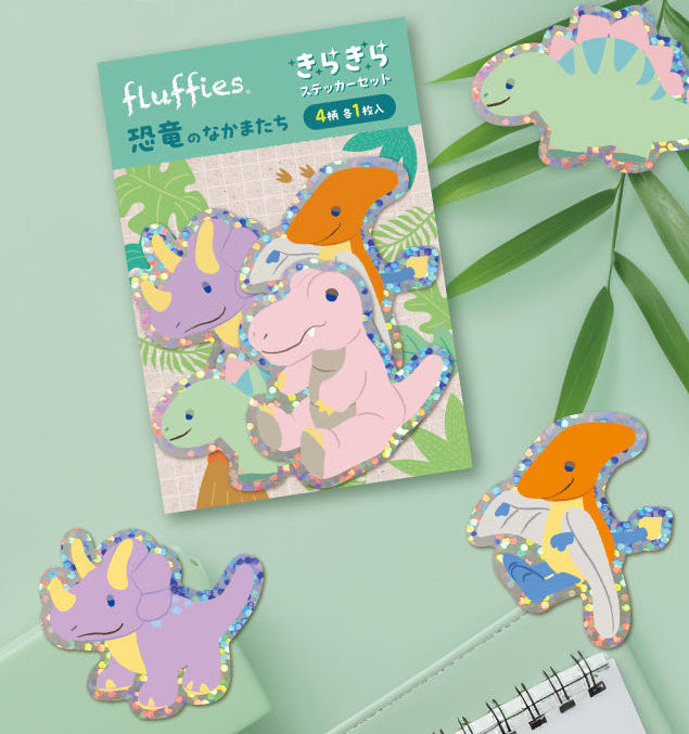 Colorful dinosaur-shaped stickers on a green background with a notebook.