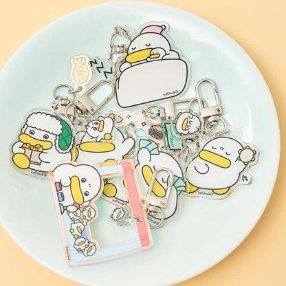 Collection of cartoon duck keychains on a white plate with a beige background