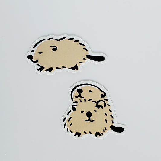 Two cartoon-style beaver stickers on a light gray background